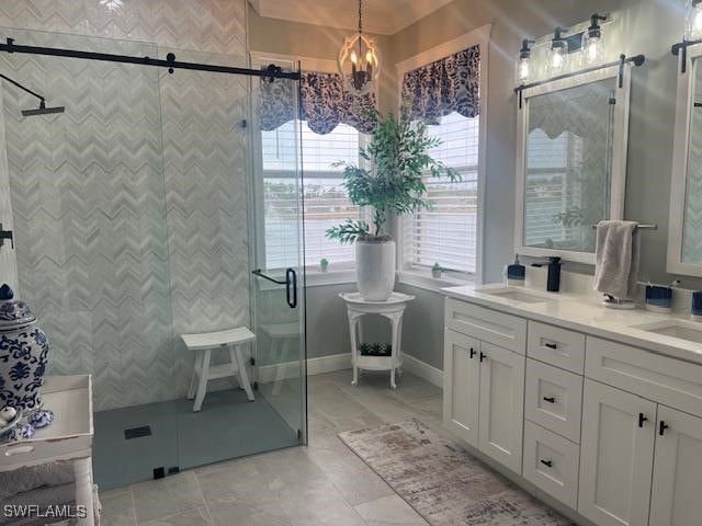 bathroom with a notable chandelier, vanity, a wealth of natural light, and an enclosed shower