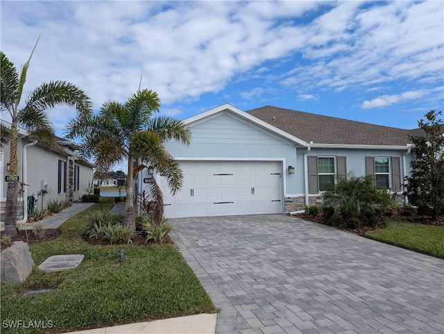 single story home with a garage and a front lawn