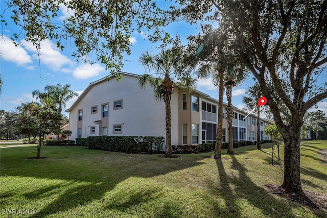 view of property exterior with stucco siding and a yard