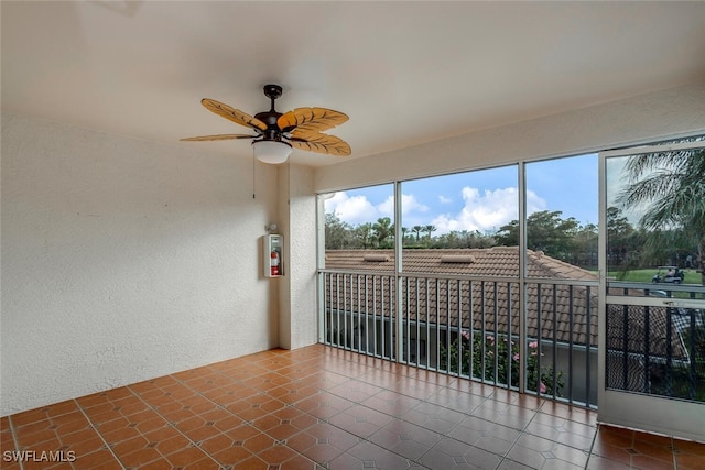 unfurnished sunroom with a ceiling fan