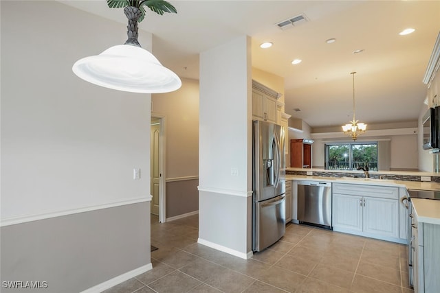 kitchen with light tile patterned floors, lofted ceiling, stainless steel appliances, visible vents, and light countertops