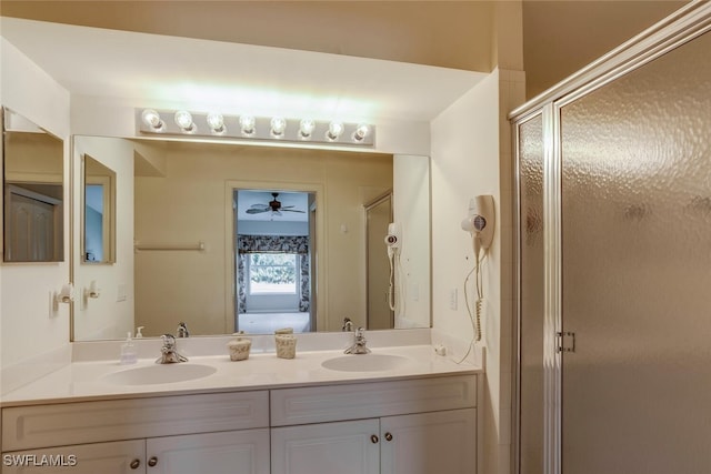 bathroom featuring double vanity, a stall shower, and a sink