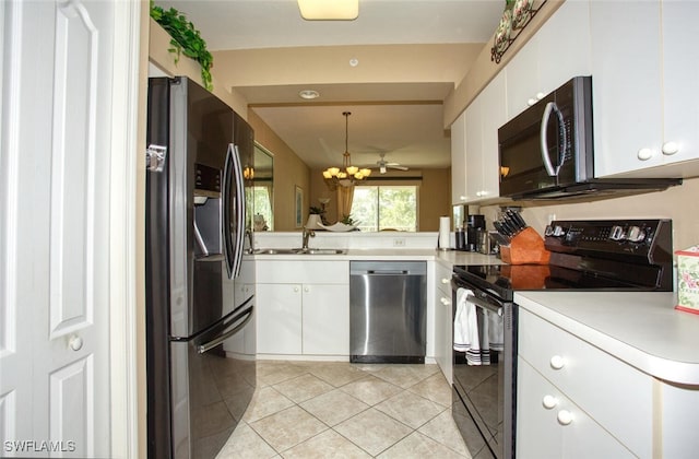 kitchen featuring appliances with stainless steel finishes, sink, light tile patterned floors, decorative light fixtures, and white cabinetry