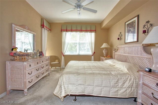 bedroom with multiple windows, ceiling fan, and light colored carpet