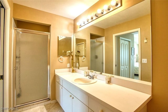 bathroom featuring tile patterned flooring, vanity, and a shower with shower door