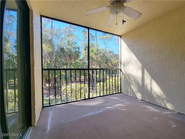 unfurnished sunroom featuring ceiling fan