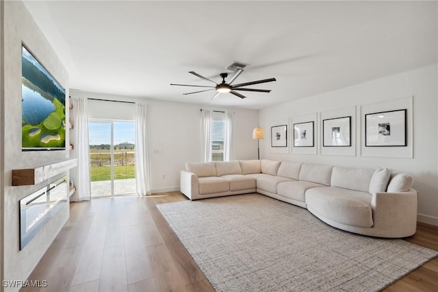 living room featuring ceiling fan and light hardwood / wood-style floors