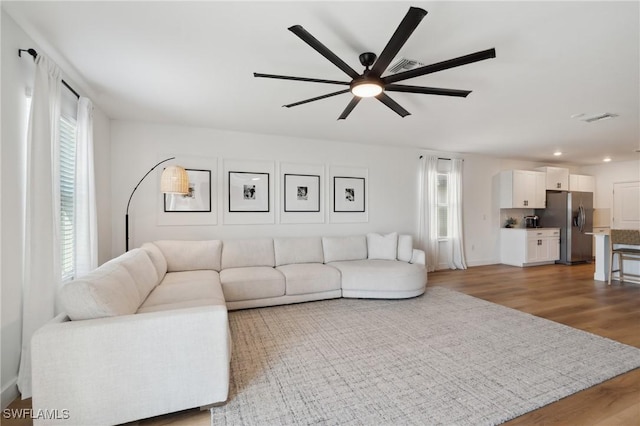 living room with hardwood / wood-style flooring and ceiling fan