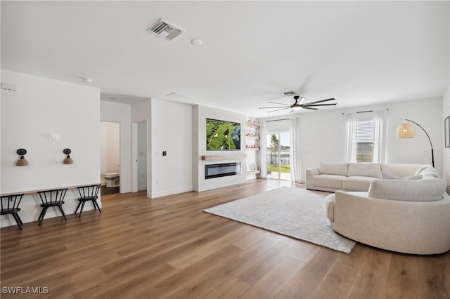 living room featuring ceiling fan and hardwood / wood-style floors