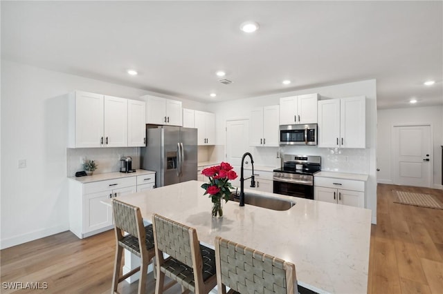 kitchen featuring light hardwood / wood-style floors, sink, white cabinetry, and stainless steel appliances