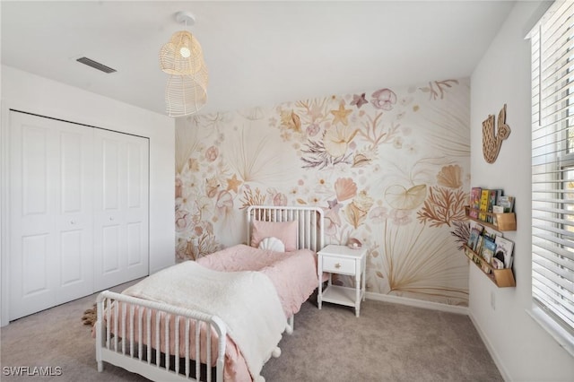 carpeted bedroom with a closet and multiple windows