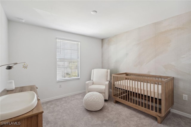 carpeted bedroom with a crib and sink