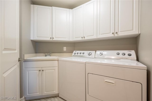 washroom with cabinets, separate washer and dryer, and sink