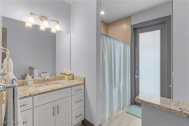 bathroom with vanity, wood-type flooring, and walk in shower