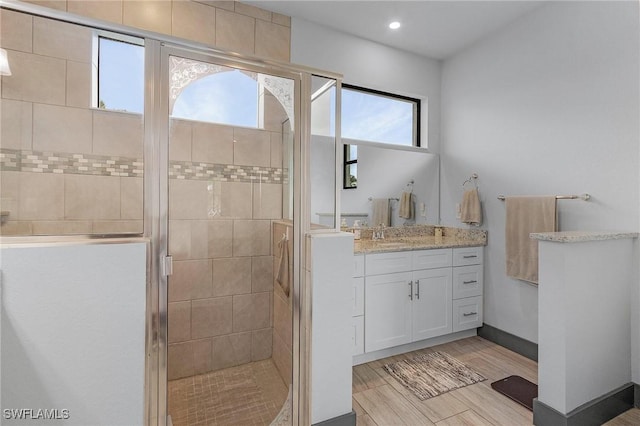 bathroom with vanity, wood-type flooring, and an enclosed shower