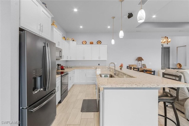 kitchen with a kitchen bar, stainless steel appliances, sink, pendant lighting, and white cabinets