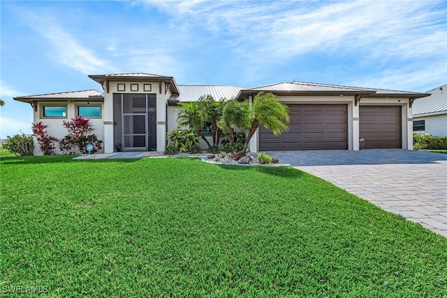 view of front of home with a front yard and a garage