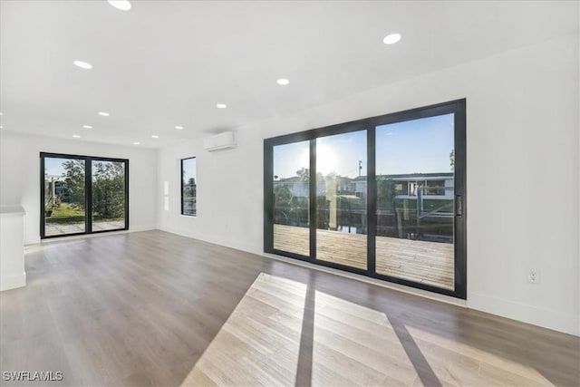 unfurnished room featuring light hardwood / wood-style flooring and a wall unit AC