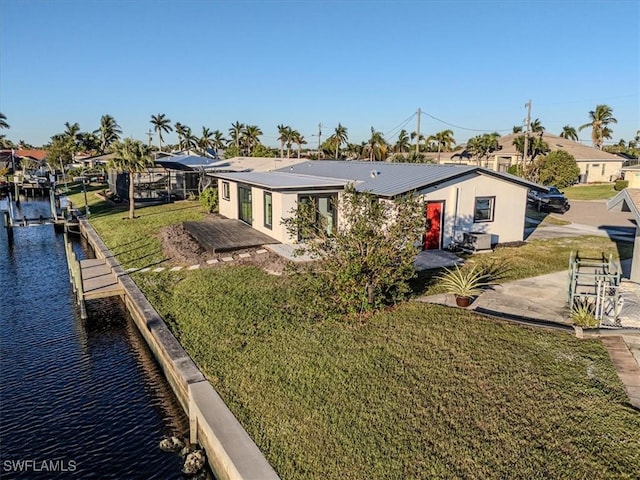 rear view of house featuring a water view, a yard, and a patio