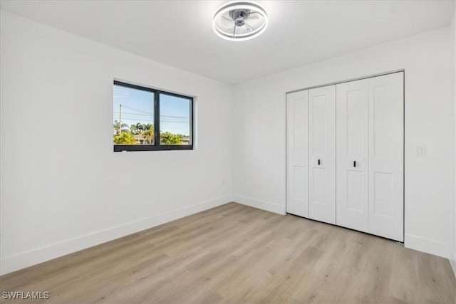 unfurnished bedroom featuring light hardwood / wood-style floors and a closet