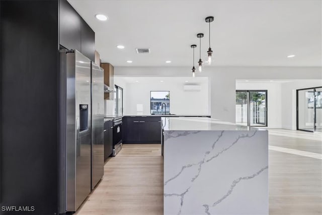 kitchen featuring pendant lighting, light hardwood / wood-style flooring, a wall unit AC, and stainless steel refrigerator with ice dispenser