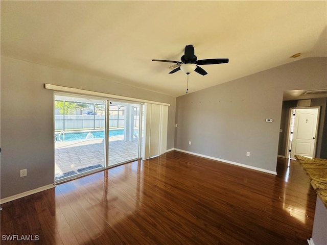 spare room with ceiling fan, dark hardwood / wood-style flooring, and vaulted ceiling