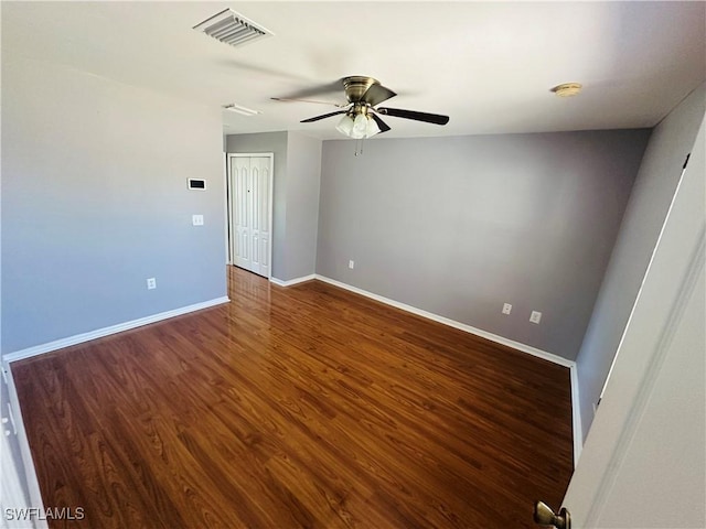 empty room with ceiling fan and dark wood-type flooring