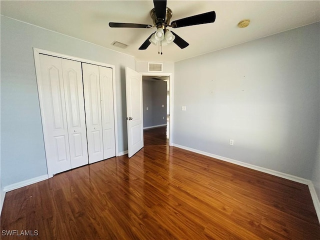 unfurnished bedroom featuring dark hardwood / wood-style flooring, a closet, and ceiling fan