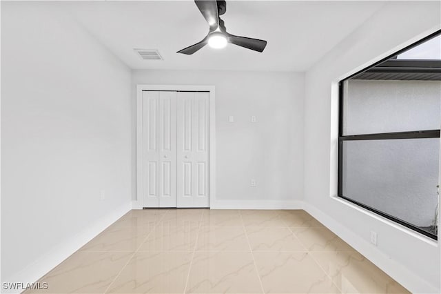 unfurnished bedroom featuring ceiling fan and a closet