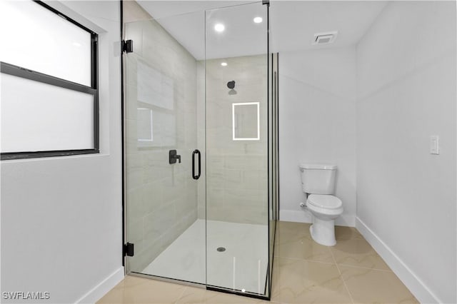 bathroom featuring tile patterned floors, a shower with door, and toilet