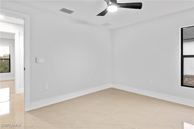 tiled empty room featuring ceiling fan