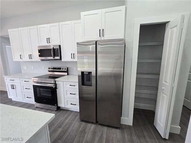 kitchen featuring stainless steel appliances, white cabinetry, light stone countertops, and dark hardwood / wood-style floors