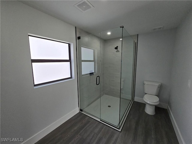 bathroom with wood-type flooring, an enclosed shower, and toilet