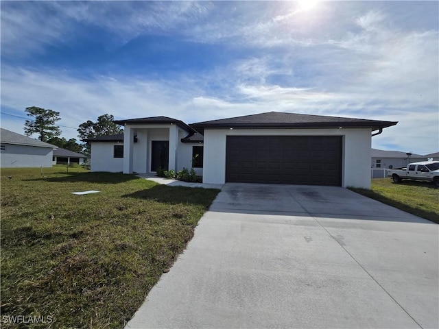 prairie-style house featuring an attached garage, driveway, a front lawn, and stucco siding