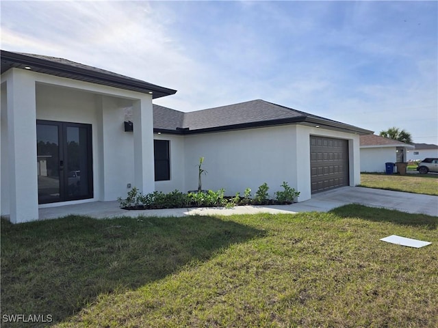 exterior space featuring a garage, french doors, and a front lawn