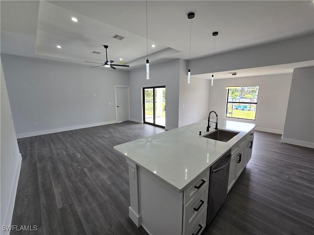 kitchen featuring white cabinetry, decorative light fixtures, a raised ceiling, and sink