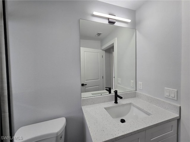 bathroom featuring vanity and toilet