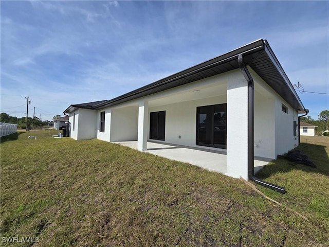 back of house featuring a patio area and a lawn