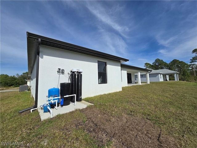 view of property exterior with central AC unit and a lawn