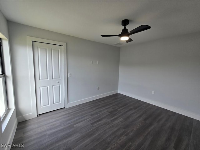 unfurnished bedroom featuring dark hardwood / wood-style flooring, a closet, and ceiling fan