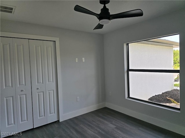 unfurnished bedroom with dark hardwood / wood-style floors, a closet, and ceiling fan