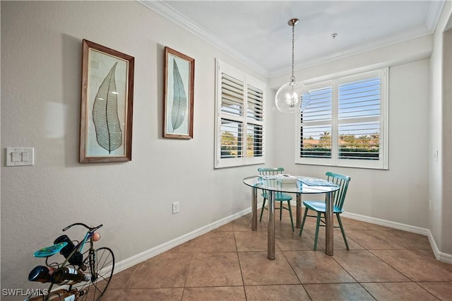 tiled dining area featuring crown molding, baseboards, and an inviting chandelier