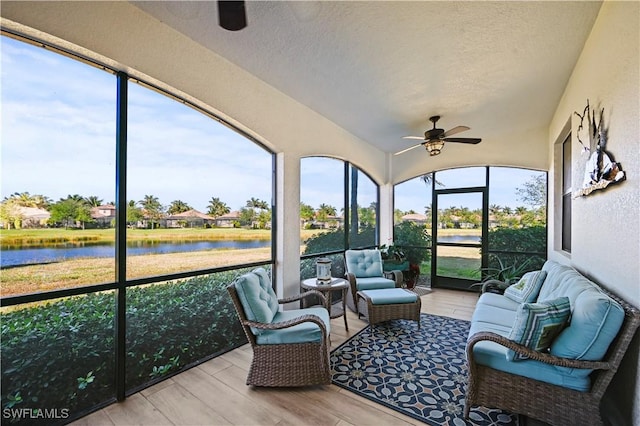 sunroom / solarium featuring a ceiling fan and a water view