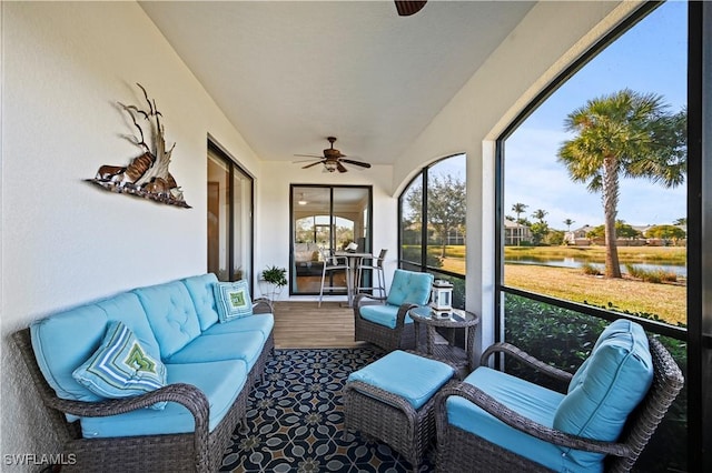 sunroom / solarium with a water view and ceiling fan