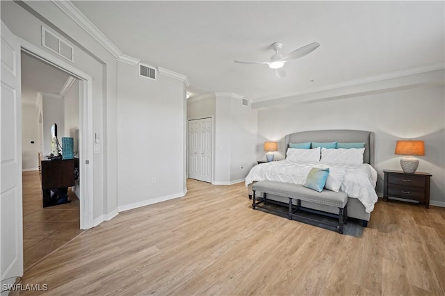 bedroom with visible vents, wood finished floors, and ornamental molding