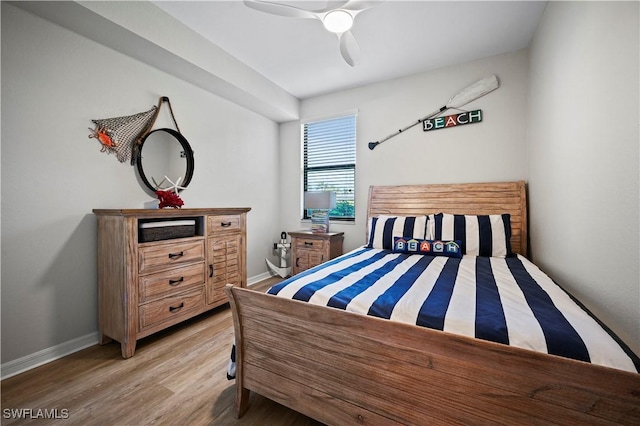 bedroom featuring ceiling fan, light wood-style flooring, and baseboards