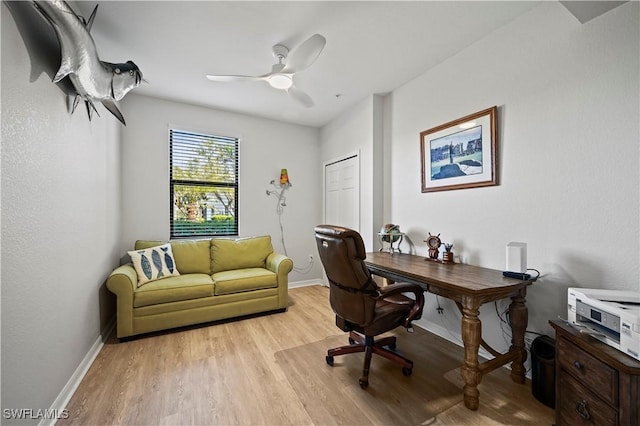 office featuring light wood-type flooring, ceiling fan, and baseboards