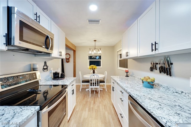 kitchen featuring white cabinets, appliances with stainless steel finishes, and light hardwood / wood-style flooring