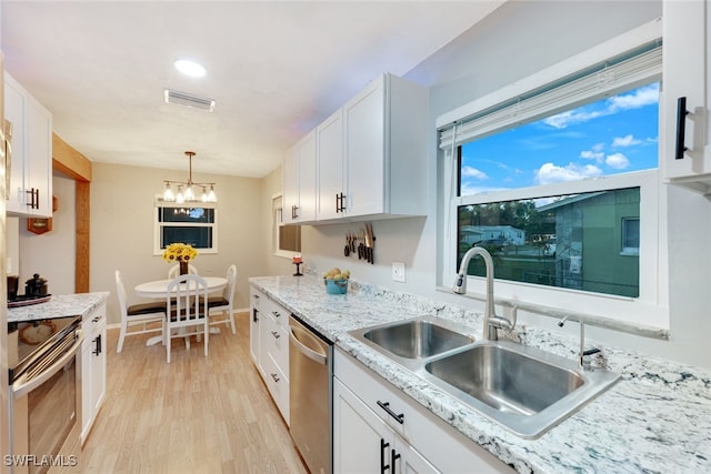 kitchen featuring sink, white cabinets, light hardwood / wood-style floors, and appliances with stainless steel finishes