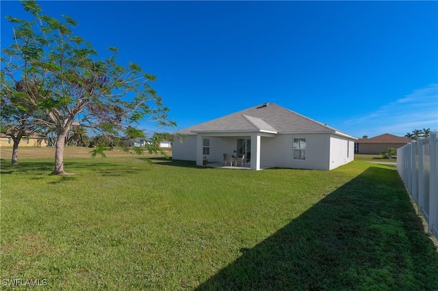 rear view of property with a yard and a patio area